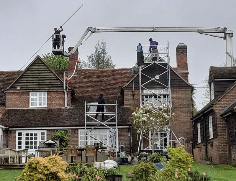 The Moss Cleaners using cherry picker and scaffolding to clean roof safely and professionally in Warminster, Wiltshire